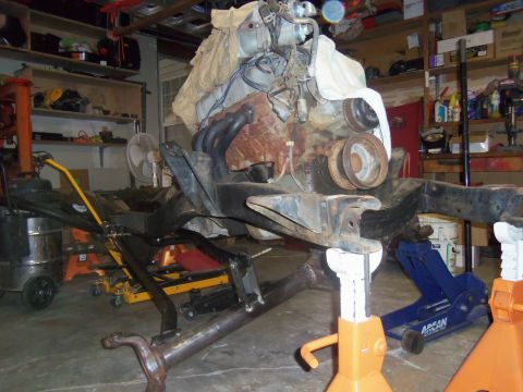 1968 Ford Bronco - Engine and chassis assembly, possibly for a 1968 Ford Bronco, is suspended in a workshop environment.