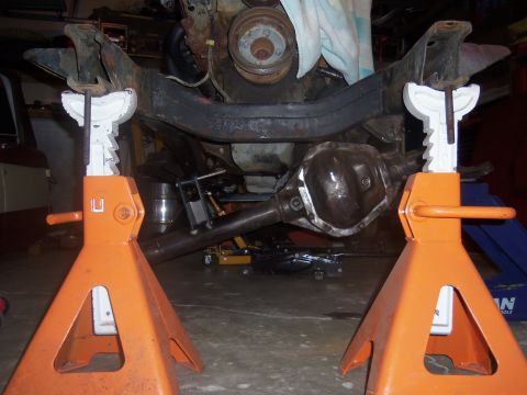 1968 Ford Bronco - Undercarriage of a vehicle, showing the frame, differential, and engine parts, supported by jack stands.
