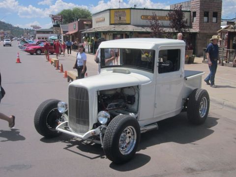 1991 Ford LTD Crown Victoria - A custom hot rod pickup truck is displayed at an outdoor car show on a sunny day.