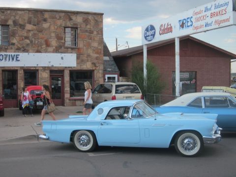 1991 Ford LTD Crown Victoria - A light blue 1955 Ford Thunderbird is parked in front of a building with a Cooper Tires sign.