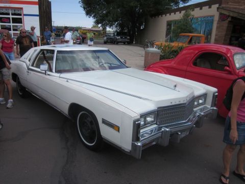 1991 Ford LTD Crown Victoria - A white 1970s Cadillac Eldorado is parked at an outdoor event with other vehicles visible.