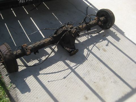 1994 Ford Bronco - A rear axle assembly, likely from a truck or SUV, is shown resting on a textured surface.