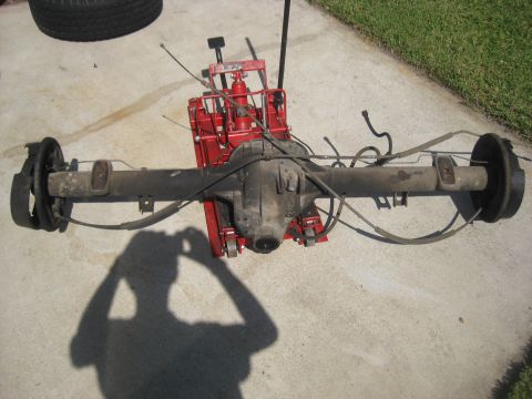 1994 Ford Bronco - Rear axle assembly removed from a vehicle and placed on a red jack for service.