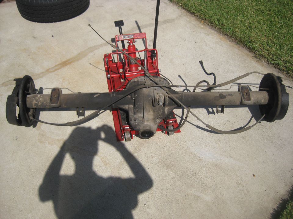 Rear axle assembly with drum brakes, supported by a red jack