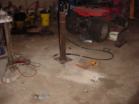 1992 Ford Bronco - A red riding mower sits in a garage surrounded by various tools and equipment.