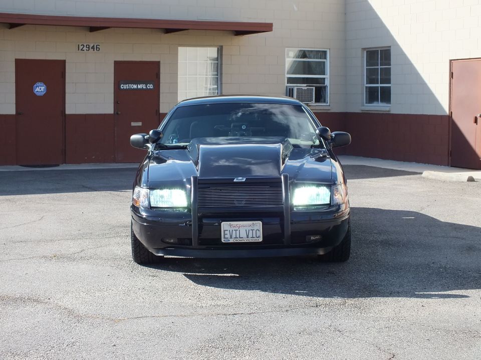 Front of black Ford Crown Victoria with push bar and EVIL VIC California plate