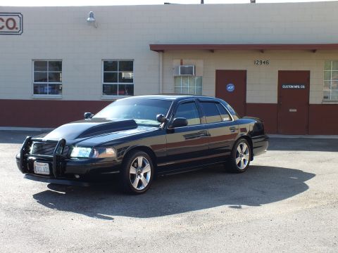 2003 Ford Crown Victoria - Front-left shot of the lowered black Ford sedan parked outside Custom Mfg. Co.