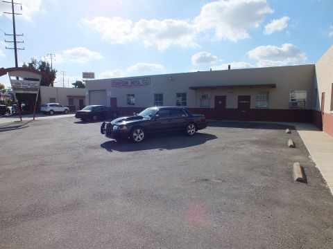 2003 Ford Crown Victoria - Distant front-left view of the black Crown Victoria in a large sunny parking lot.