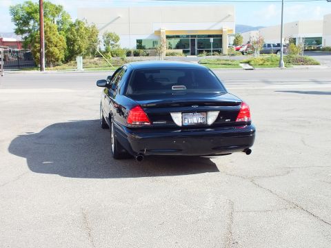 2003 Ford Crown Victoria - Straight rear view of the black sedan showing Ford oval, EVIL VIC plate and dual exhaust.