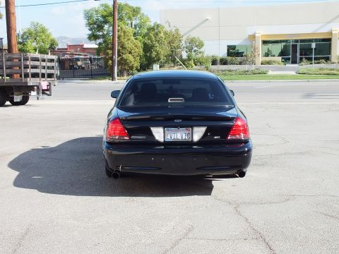 2003 Ford Crown Victoria - Rear shot of the black Ford sedan with taillights, dual tips and CA EVIL VIC plate.
