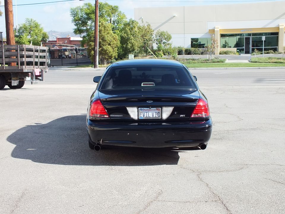 Rear view of black Crown Victoria with dual exhaust and EVIL VIC California plate