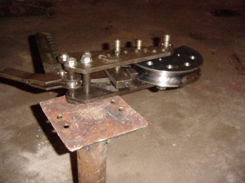 1992 Ford Bronco - A shop-built hydraulic tubing bender head mounted on a welded steel pedestal with a bare plate top, showing the round bend die, follower ar…