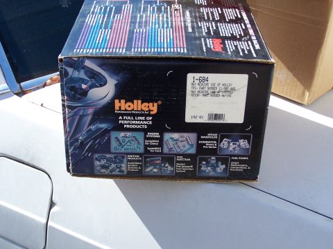 1991 Ford LTD Crown Victoria - A Holley performance parts box is placed on the hood of a white car.