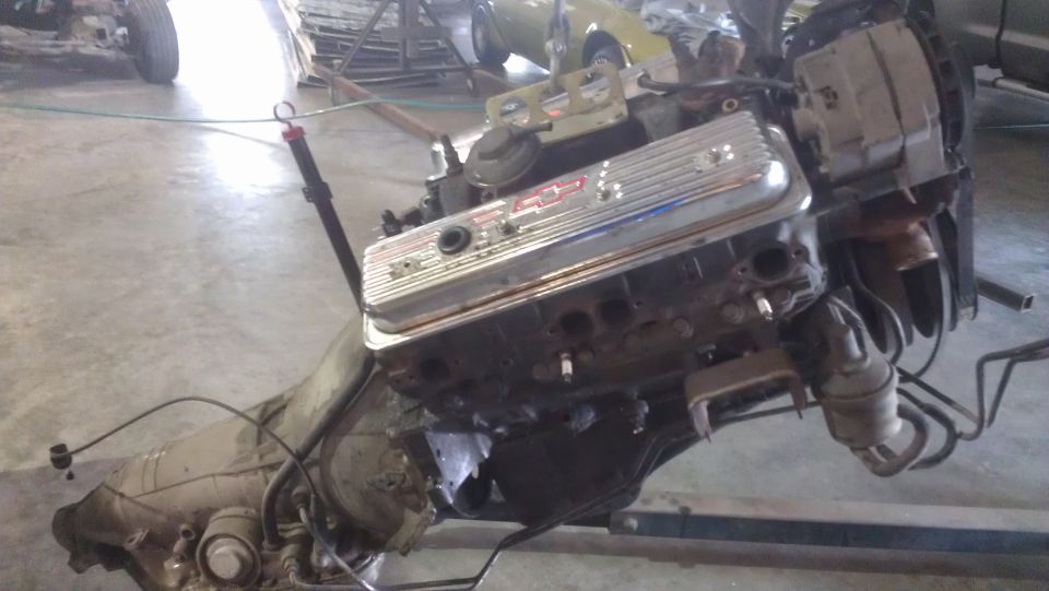 V8 engine with chrome valve covers and transmission assembly, possibly for a classic car