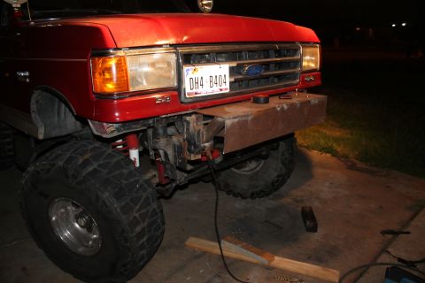 1990 Ford Bronco - A red Ford truck is shown with a custom-built metal bumper, obscuring the original front end.