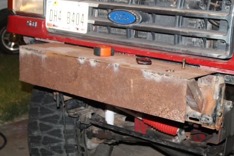 1990 Ford Bronco - Custom bumper fabrication on a red truck, with a visible Ford emblem and license plate.