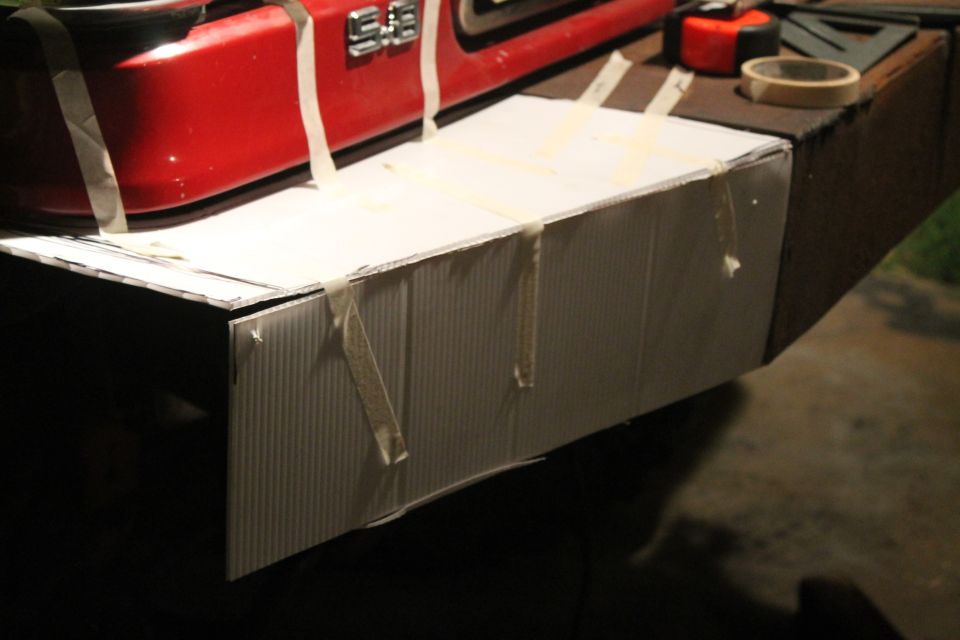 Red bumper section with "S.E." badge, taped to a cardboard extension