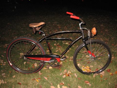 1994 Ford Bronco - Cruiser bicycle with vintage styling and red accents sits on a grassy lawn at dusk.