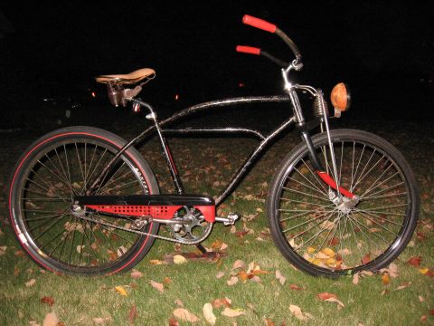 1994 Ford Bronco - A custom cruiser bicycle with a black frame and red accents sits on a grassy lawn at night.