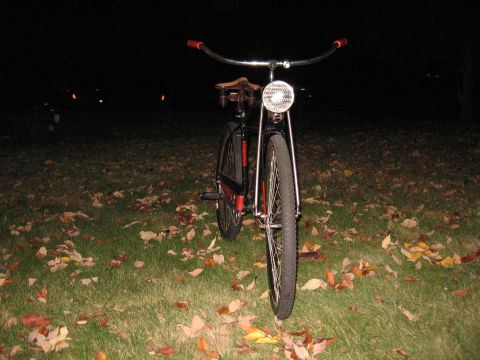 1994 Ford Bronco - A bicycle with a vintage aesthetic is shown from the front, illuminated by its headlight against a dark background.