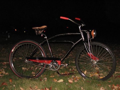 1994 Ford Bronco - A custom cruiser bicycle with red accents and a vintage-style headlight is displayed outdoors at night.