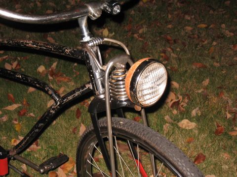 1994 Ford Bronco - Close-up of a vintage bicycle's front wheel, headlight, and handlebars, set against a backdrop of fallen leaves.