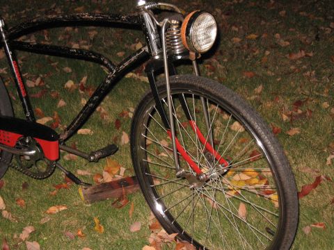 1994 Ford Bronco - A black bicycle with a vintage headlight is parked on grass with fallen leaves.