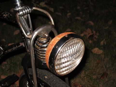1994 Ford Bronco - Old bicycle headlight with visible rust and chrome suspension springs.