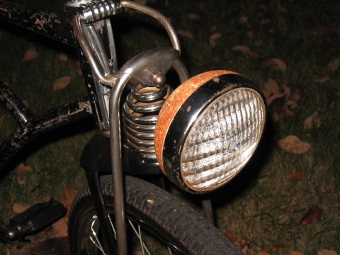 1994 Ford Bronco - The front of an old bicycle, showing a weathered headlight and suspension system.