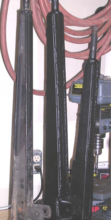 1994 Ford Bronco - Three black metal jack stands are shown, with a drill press and air hose visible.
