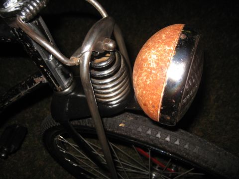 1994 Ford Bronco - A close-up view of a vintage bicycle's front end, highlighting its rusty headlight and suspension system.