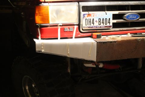 1990 Ford Bronco - A red Ford Bronco's front end is shown with a custom metal bumper and a Texas license plate.