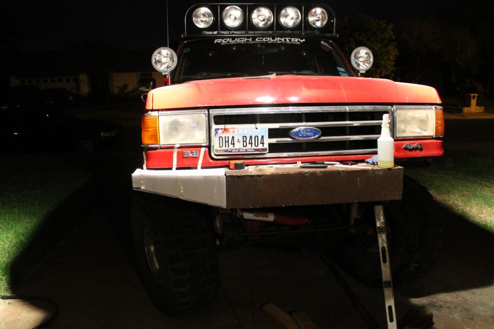 Red 1990 Ford Bronco front view with custom bumper and light bar