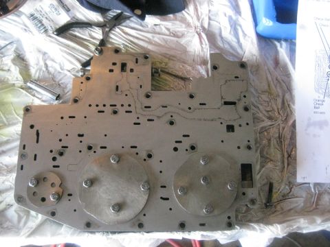 1994 Ford Bronco - A disassembled transmission valve body is laid out on a white tarp with tools and a diagram.