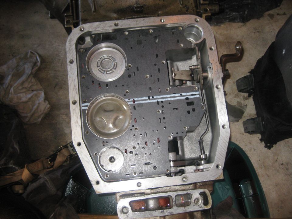 Transmission valve body with filter and torque converter clutch visible, metal casing, grey and black components