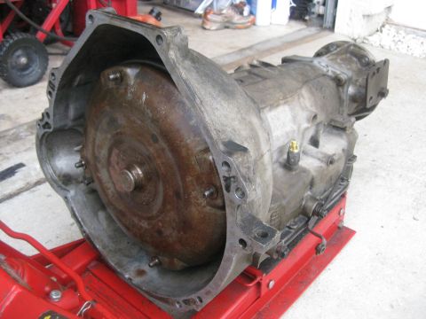1994 Ford Bronco - An automatic transmission and torque converter assembly is shown on a red stand, likely for repair or rebuild.