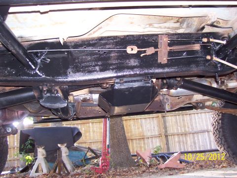 1990 Ford Bronco - The undercarriage of a 1990 Ford Bronco is visible, supported by jack stands and a high-lift jack.