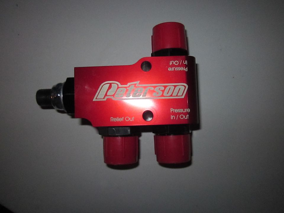 Red Peterson pressure regulator with 'Relief Out' and 'Pressure In / Out' labels