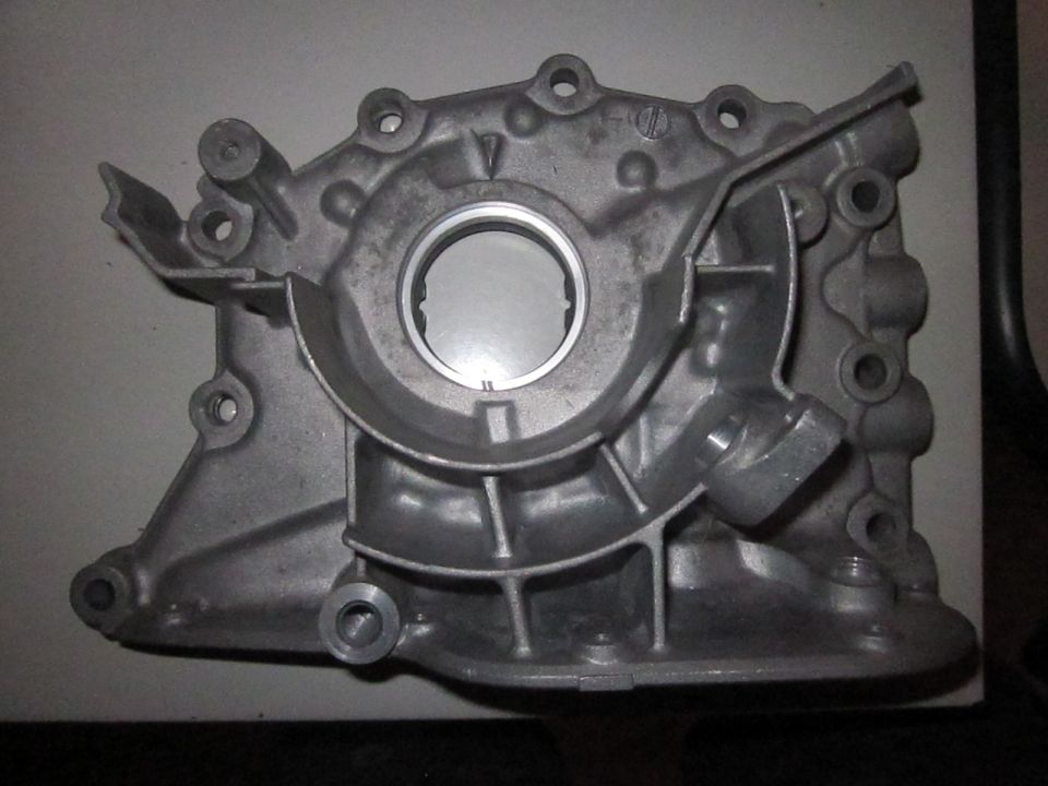 Aluminum engine oil pump housing with circular opening and mounting holes