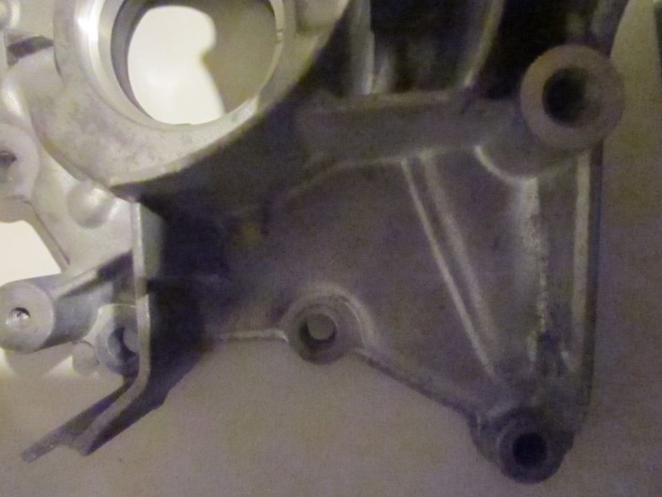 Close-up of a metal engine component with mounting points