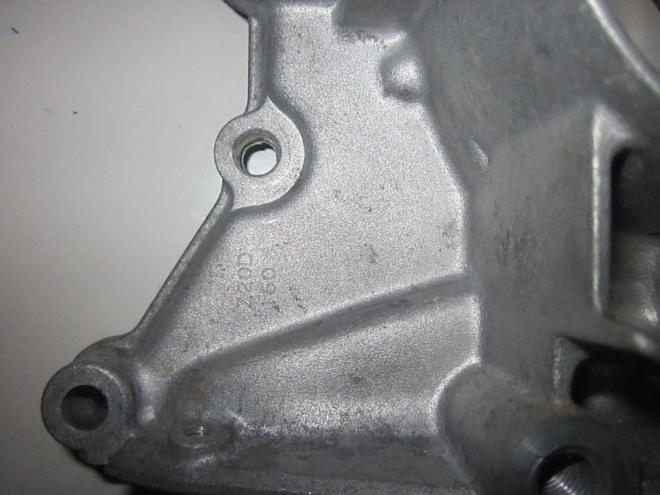 Close-up of a metal casting with stamped numbers '220D' and '160'