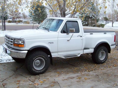1993 Ford F-150 - This Ford F-250 pickup truck is parked on a driveway with fallen leaves and a dusting of snow.