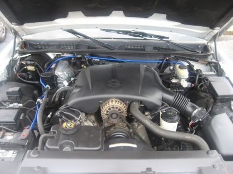 1998 Ford Crown Victoria - The engine bay of a 1998 Ford Crown Victoria, a black engine cover and visible blue hoses.
