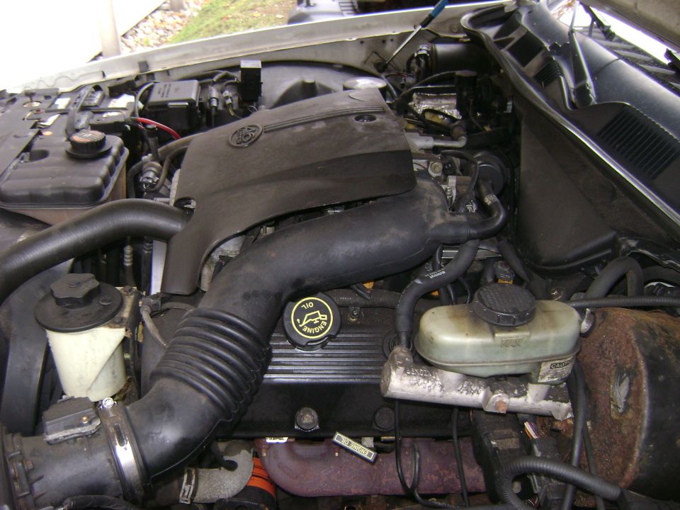 1998 Ford Crown Victoria engine bay with air intake, oil cap, and brake fluid reservoir visible