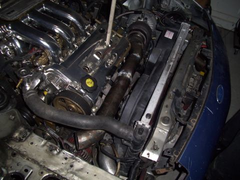 1995 Ford Probe - Engine bay of a 1995 Ford Probe, showing a chrome intake manifold and custom turbo piping.