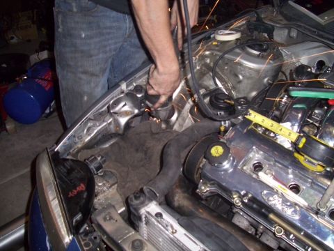1995 Ford Probe - Grinding metal in the engine bay of a car, with a tape measure on the valve cover.