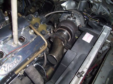 1995 Ford Probe - Close-up view of a modified engine a turbocharger and custom exhaust components.