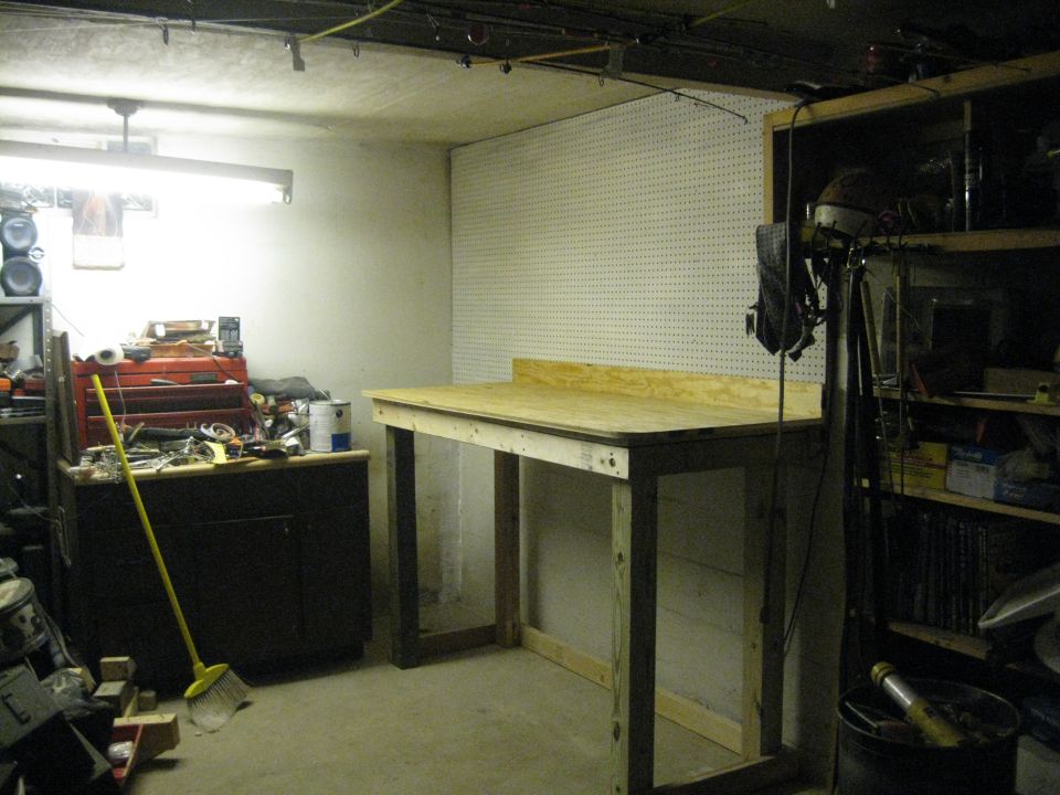 Workbench in a cluttered garage with tools and storage shelves