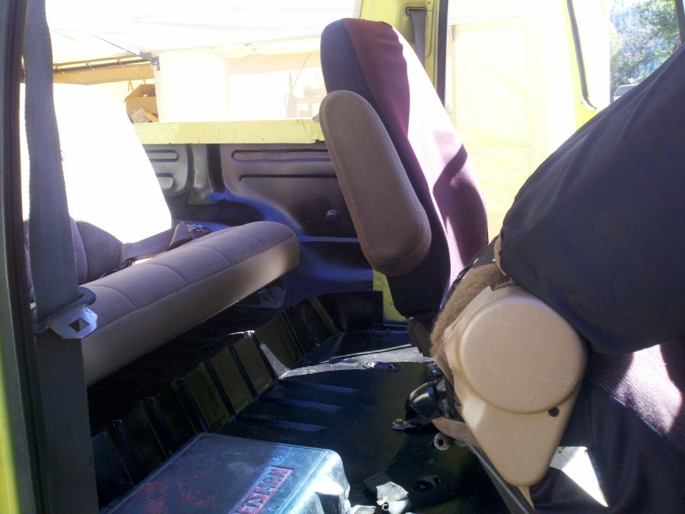 Interior view of a vehicle, showing seats and floor. Text on a box reads 'SUPERMOTORS'