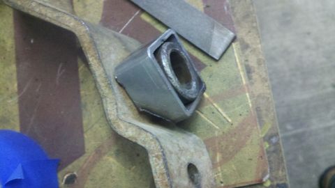 1978 Ford Bronco - Close-up of a metal bracket and bushing, with a file nearby.